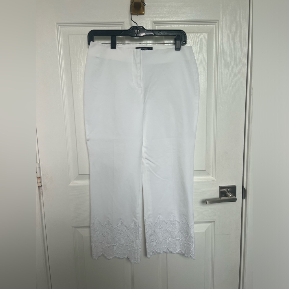 White thick wide leg pants with intricate detailing at the bottom